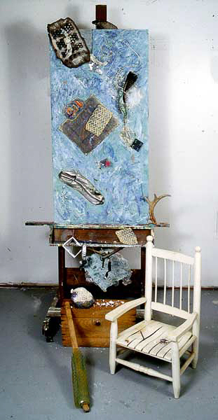 LOSS: ROADKILL size variable ht. 6 ½ feet. Installation of old wooden easel: Painted wall board; found objects; paper; encaustic; wood; metal car parts; mirror; foam; lace; telephone wire; feather; deer antler; plaster;etc. and child’s Small old white chair.